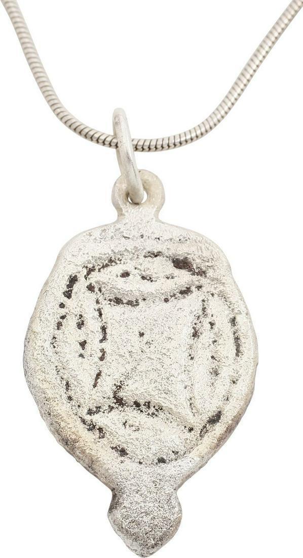 GOTHIC EUROPEAN NECKLACE PENDANT, 12th-15th CENTURY: Made by the open face mold process. Silver on bronze, shield-shaped with raised rounded edge and trefoil pendant. The field with an irregular curvilinear figure, probably heraldic (from the owner's co