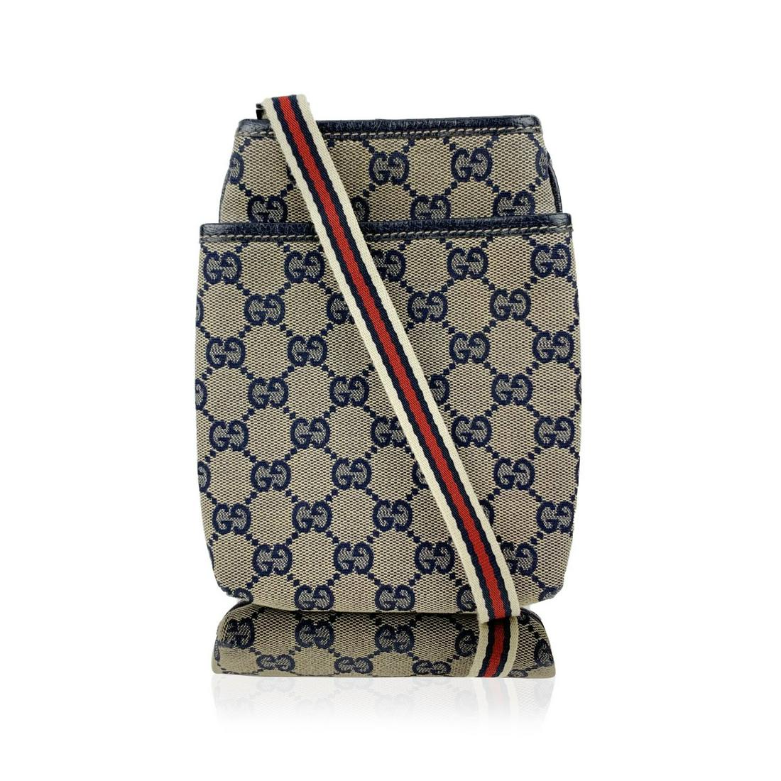 Gucci Blue Monogram Canvas Small Crossbody Messenger: Small Gucci blue monogram canvas messenger bag. Blue monogram canvas with genuine leather trim. Blue/Red/White striped canvas shoulder strap. Button closure on top. Blue lining. 'GUCCI - Made in Italy