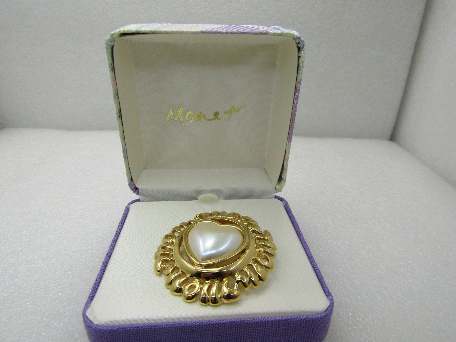 Vintage Monet Faux Pearl Heart Brooch with Frame that: Vintage Monet Faux Pearl Heart Brooch with Frame that Looks like MOM repeated, in Original Box, Vintage New. IIN lavender and sage glitterly hinged Monet box and the piece is signed Monet - 1980's-199