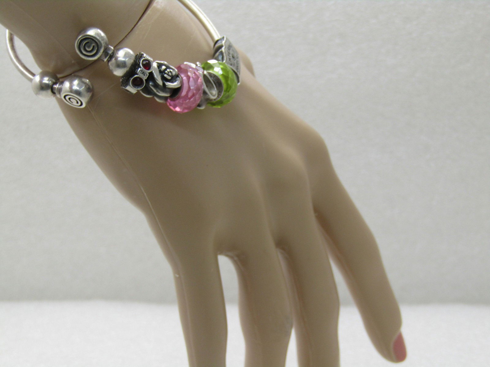 Sterling Silver Chamilia Charm Bracelet with 7 Charms,: Sterling Silver Chamilia Charm Bracelet with 7 Charms, Two Beads, 7", 38.12 gr. Two 8mm s tering beads at the end of the offset cuff that has flat rounded beads signed C in a circle one ach side. The