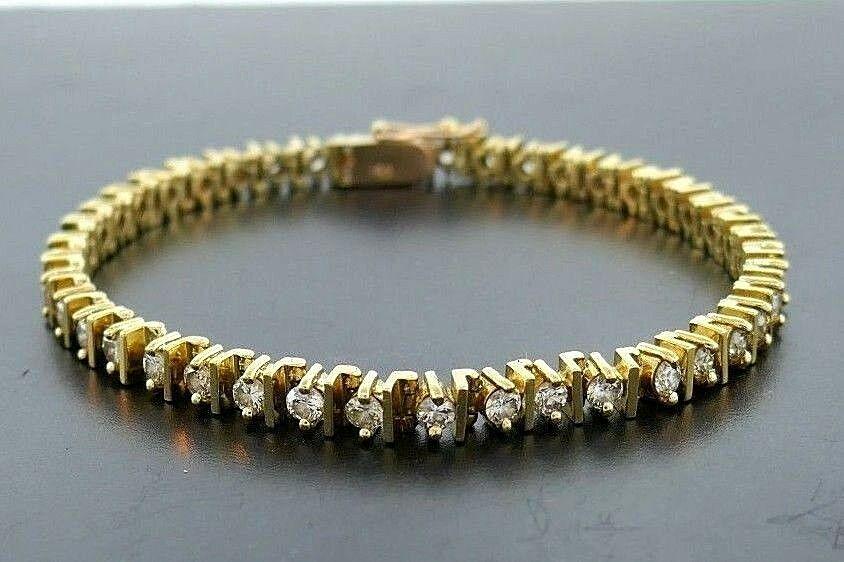 14k Yellow Gold Diamond Tennis Bracelet: NS JU00 Classy and casual 14k yellow gold diamond tennis bracelet Total diamond weight is 3 carats Stamped with a hallmark for 14k gold Measurements: Length is 9 inches, width is 1/8 inch Weight is 17