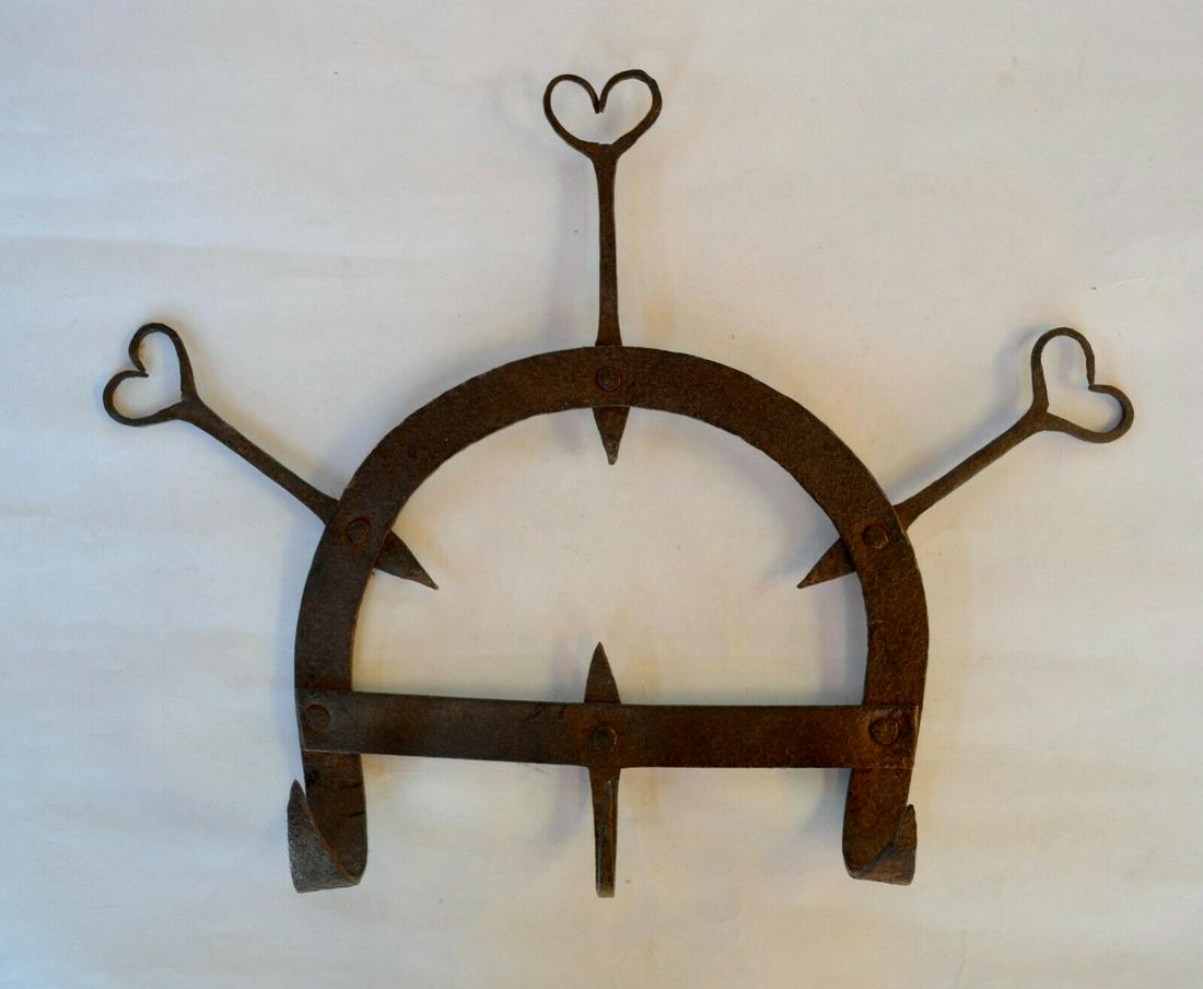 Wrought Iron Wall Rack with Heart Finials: Fine wrought iron wall rack with three heart finials. The three upcurved hanging loops are sharp, so probably this was used as a game rack. Riveted construction. Excellent condition with allover light
