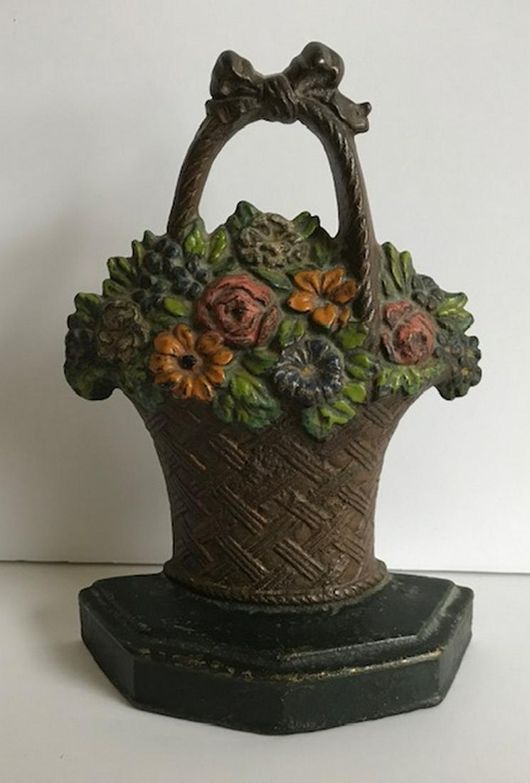 Flower Basket door stop: Title: Flower Basket door stop Provenance/Additional Info: Cast iron door stop of a woven basket filled with flowers in good warm original paint. Dates to the early 20th century and measures 7" tall b