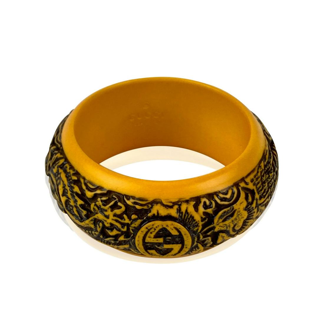 Gucci Yellow Dragon Carved Logo High Bangle Bracelet: Beautiful bangle bracelet by Gucci from the 2018 Fall collection. Made in yellow resin. It features a stunning engraved dragon motif with carved Gucci Logo on top. Size: S. Inner circumference: 7.5 in