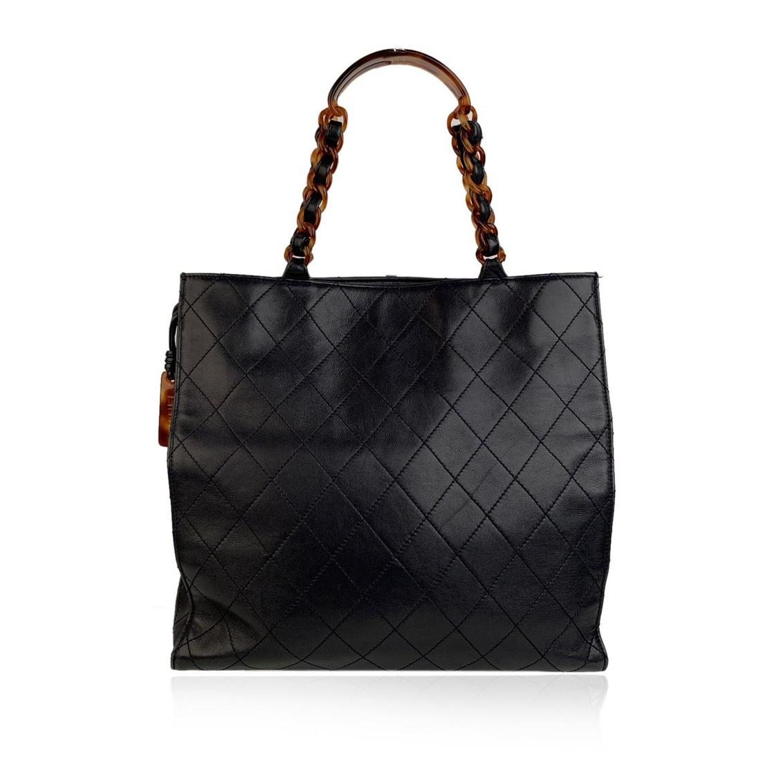 Chanel Vintage Blue Quilted Leather Tote Bag Shopper: CHANEL Vintage Shopping Tote in Navy Blue quilted leather from the 90s. Tortoise chain link top handles threaded with leather. Tortoise lucite Chanel pendant detailing on the side. Double magnetic but