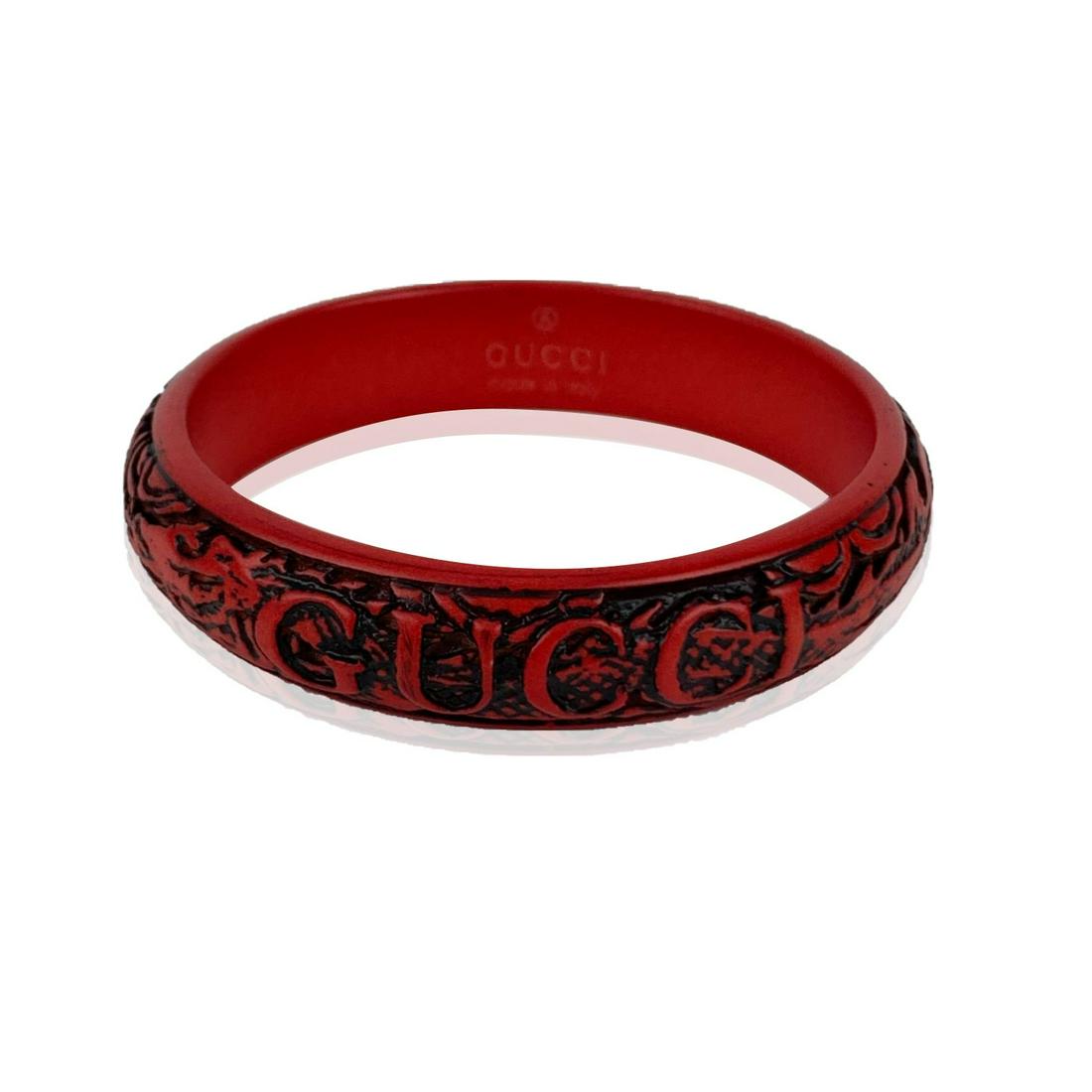 Gucci Red Dragon Resin Engraved Logo Bangle Bracelet: Beautiful bangle bracelet by Gucci from the 2018 Fall collection. Made in red resin. It features a stunning engraved dragon motif with carved Gucci name on top. Size: L. Inner circumference: 9 inches 