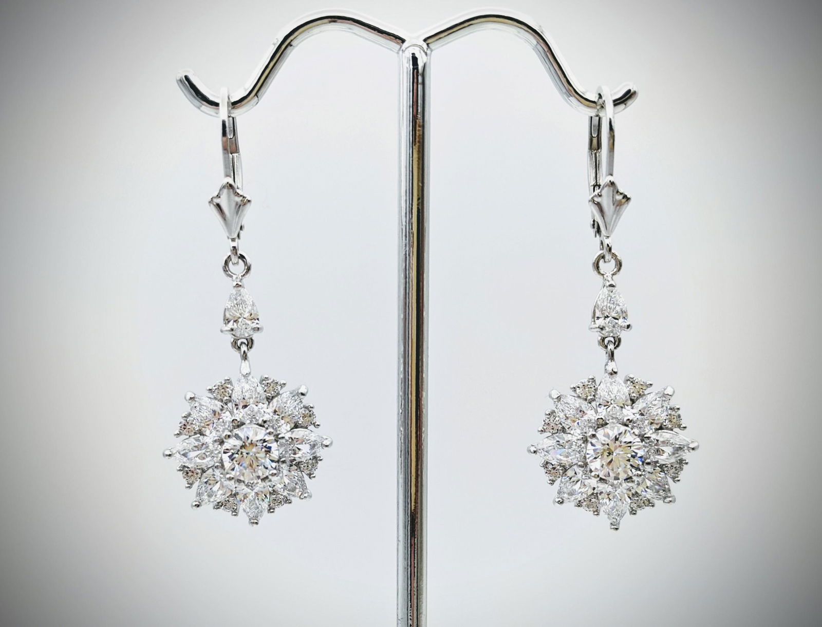 Sterling Silver Clustered Cubic Zirconia Drop Earrings: Title: Sterling Silver Clustered Cubic Zirconia Drop Earrings Brand: Jean Lin Collection Metal Purity: 925 Sterling Silver Gemstones: Cubic Zirconia Carat Weights: Each Earring has 1 Round Cubic Zirco