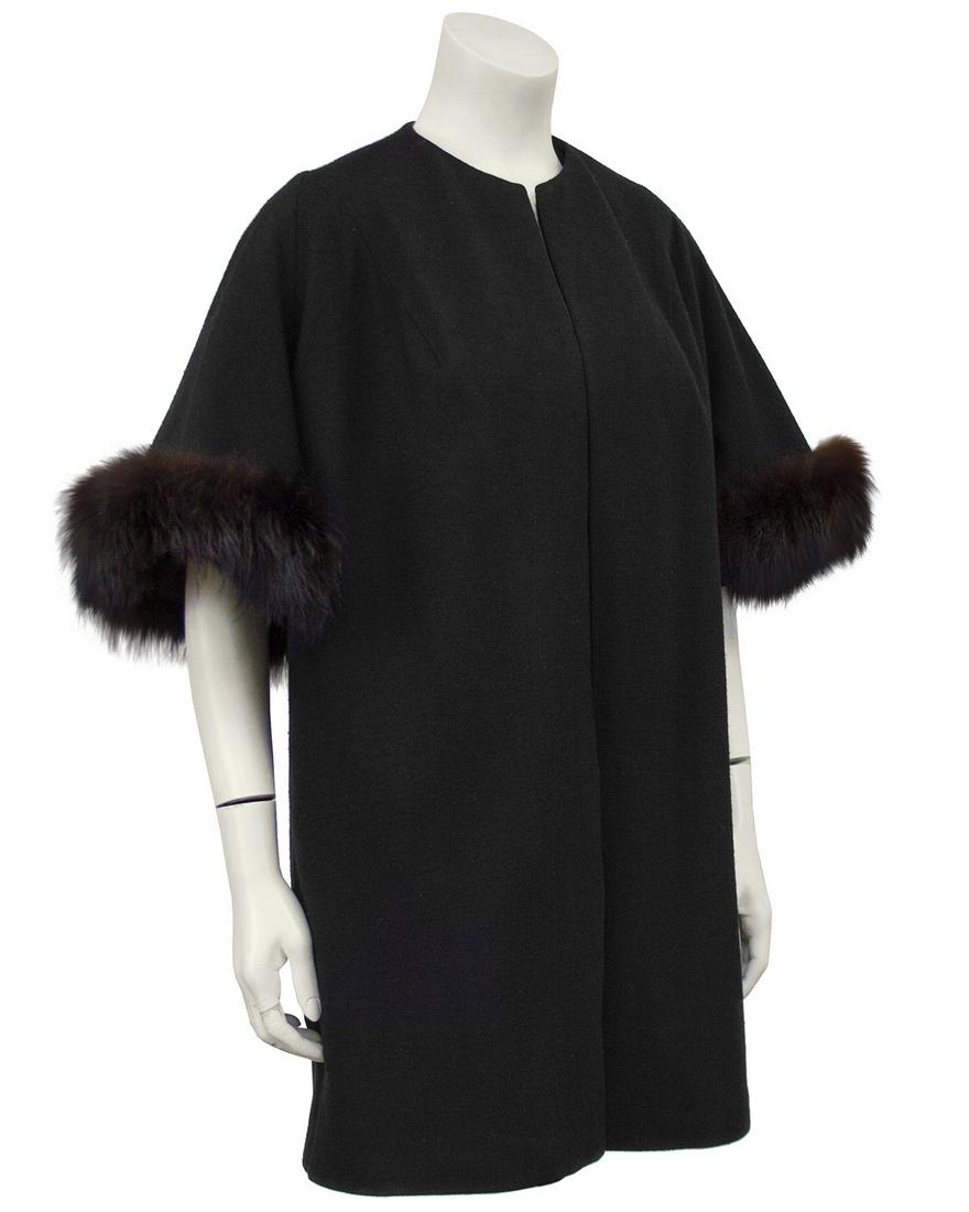 Anonymous Black Mini Opera Coat with Fur Trim: Black wool jersey 1950s 3/4 length opera style coat with black fox fur trim on the short sleeves. The perfect piece for over a cocktail or evening dress but also would be chic with jeans. Fully lined