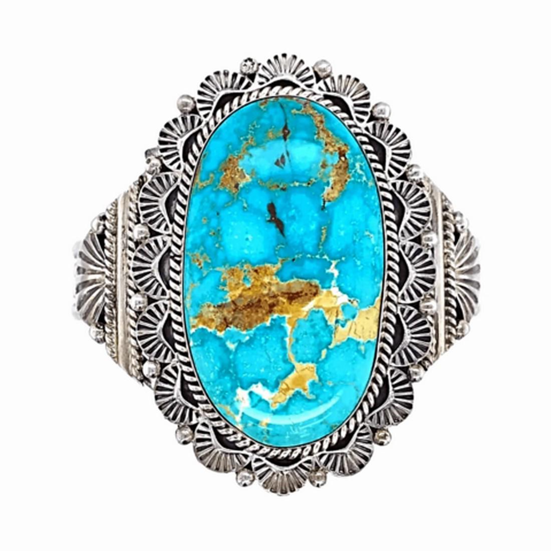 Large Turquoise Mountain Embellished Silver Bracelet: This dynamic piece features an embellished silver setting with a gorgeous Turquoise Mountain stone. Measurements: Band Width: 2/8" Top/Front Design: 2 3/8" long, 1 3/4" wide (tapers to 2/8") Stone Siz
