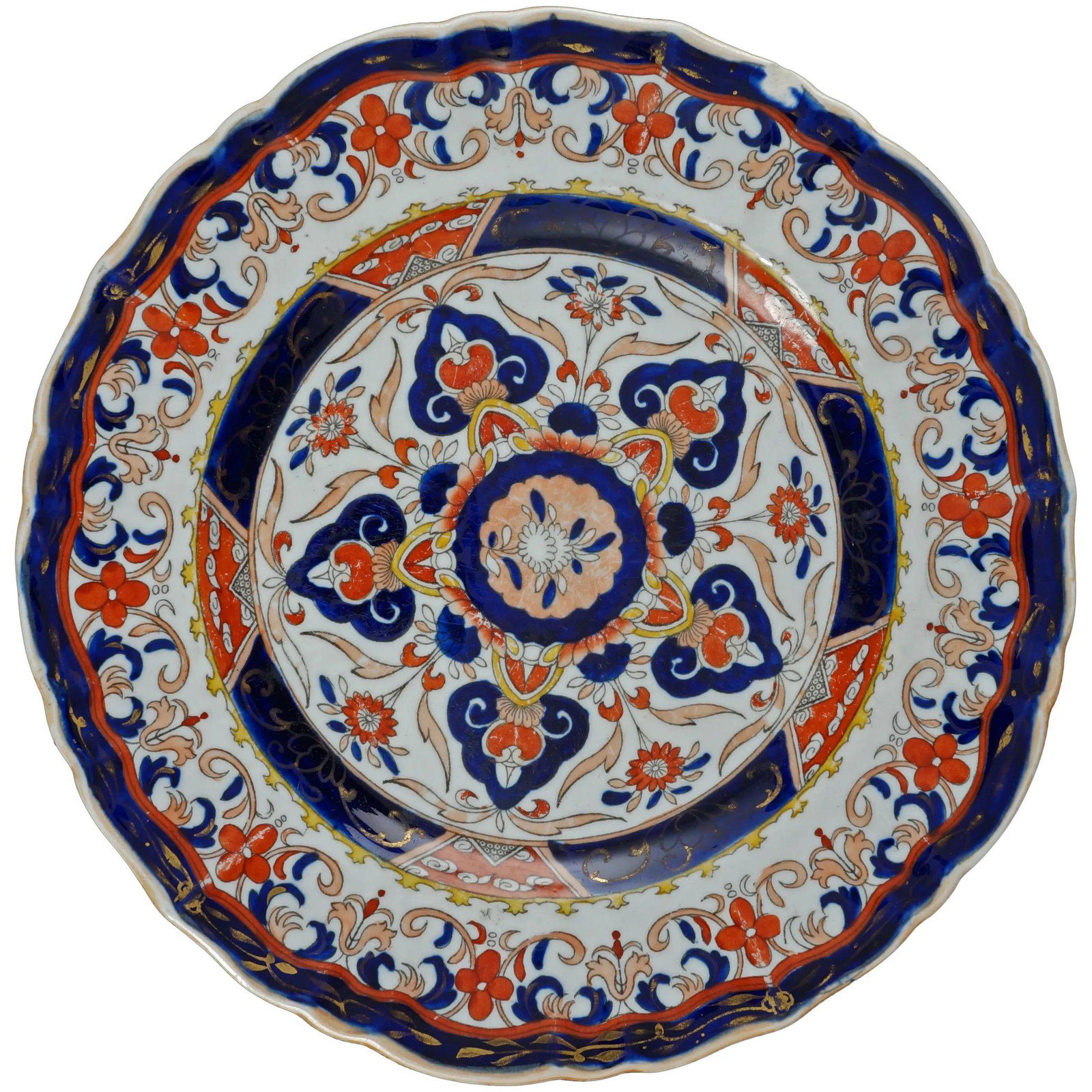 English Mason’s 19th C Transferware Ironstone Plate: A heavy, colorful and large antique plate with a transferware pattern of Japanese Imari. The heavy molded plate has a deep indigo blue and iron red transfer design of flowers, arabesques, and triangul