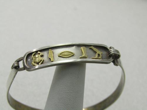 Vintage 14kt & Sterling Egyptian Cartouche Bangle: Vintage 14kt & Sterling Egyptian Cartouche Bangle Bracelet, 7", Top Opening with a hook clock. The bracelet has a sterling 5.5mm wide band with a curved cartouche on top with 14kt beetle, quill, eye,