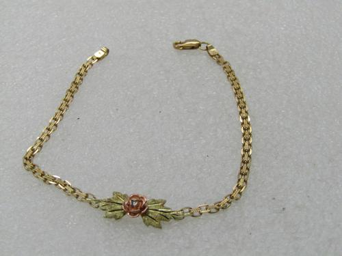 Vintage 10kt Black Hills Gold Rose Bracelet, Diamond: Vintage 10kt Black Hills Gold Rose Bracelet with Diamond Chip, 7.25" Two-Tone. Rose gold rose with a diamond chip in the center sitting over two gold tone diamond cut leaves. The chain is a textured w