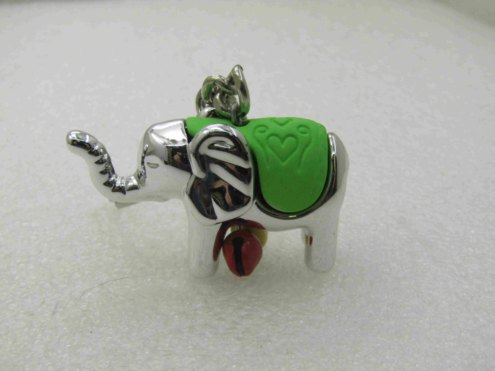 Elephant Key Ring, Green Saddle with Heart, Bells: Elephant Key Ring, Green Saddle with Heart, Bells. 1.5" wide and 1.25" tall, red and yellow enameled bells. Very good, new condition. Not signed by maker. (INV. W. 91920.2 SS2934 J LD 11/26/20). Reser