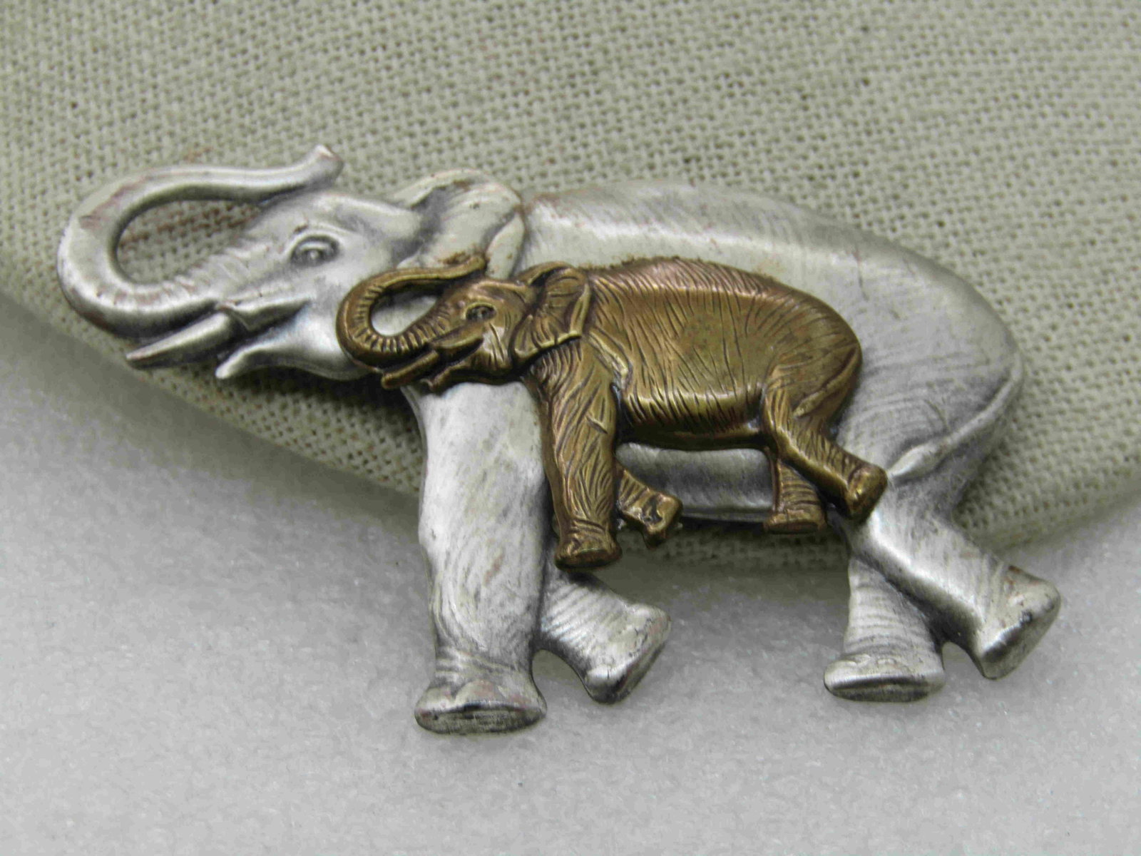 Vintage Two-Two Elephant Brooch, 2.75": Vintage Two-Two Elephant Brooch, 2.75" by 2". Large silver tone satiny washed finish on the larger elephant with bras tone overlaying the larger elephant. Pressed metal. Age is papx. 1980's-1990's. No