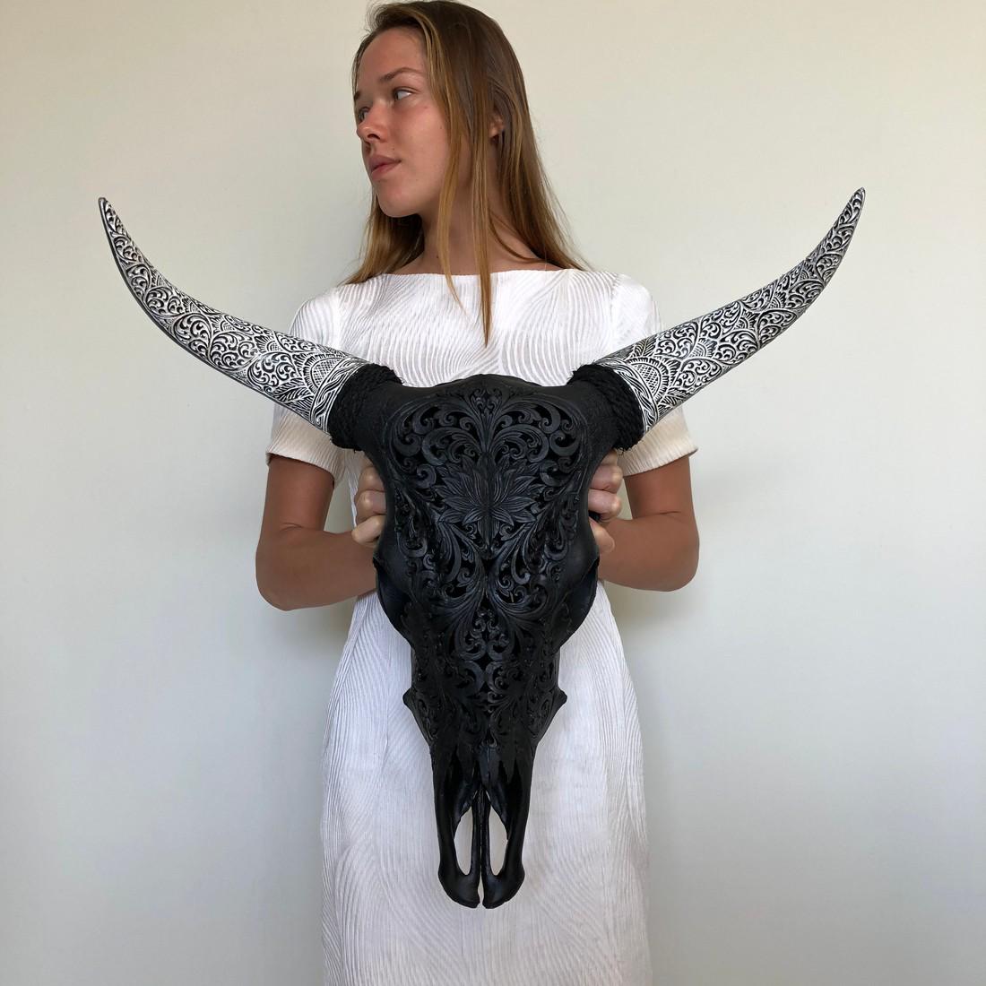 Bos Taurus 'Cow' Skull with Lotus Carving and Bohemian: Title: Bos Taurus 'Cow' Skull with Lotus Carving and Bohemian Fully-Carved Horns Maker: Design: Sooka Interior Origin: Indonesia Date/Period: 2019 Materials: Bone Dimensions:DIMENSIONSWidth 56cm / 22 