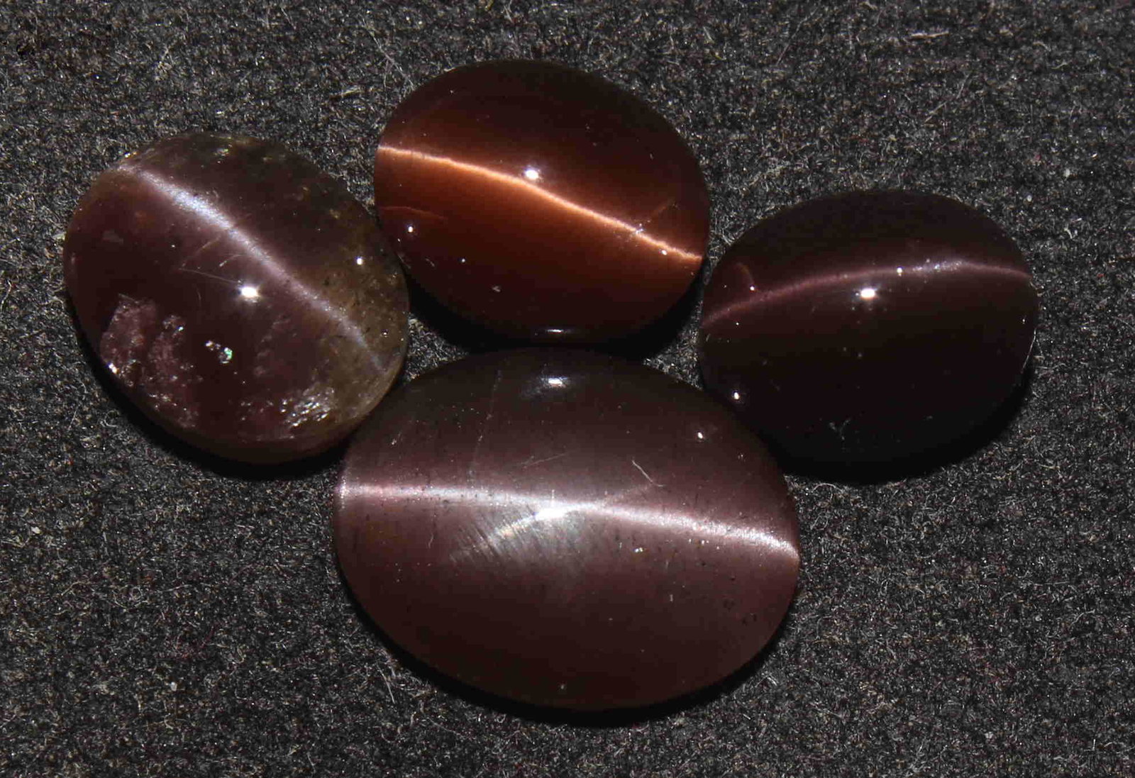 12.64 Cts Natural Scapolite Cat's-Eye: No Reserve! Gemstone : Natural ScapoliteVariety: Cat's-Eye ScapoliteOrigin: MadagascarWeight: 12.64 CaratsDimensions: 12.5x9.5x3.5 mm - 9x7x6.1 mmShape/Cut: Oval CabochonNumber of Stone : 4Colour: Red