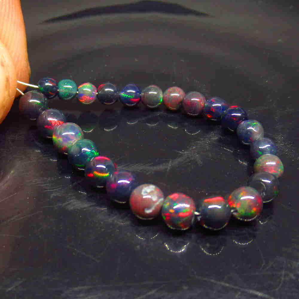 6.35 Ctw Natural 25 Drilled Black Fire Opal Ball Beads: No Reserve! Title: 6.35 Ctw Natural 25 Drilled Black Fire Opal Ball Beads Color/Clarity: Translucent Gemstone:Black Opal Beads Carat Weight: 6.35 Size/Dimensions: 3.30 to 4.50 mm / 25 PC's Additional 
