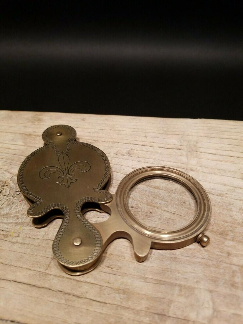Pocket Folding Glass Magnifying Lens Fleur de Lis: 6 1/8" at its longest open... 4 3/8" closed Nice reproduction of an antique brass flip out Magnification glass or lens. Magnifying glasses like this were used in the 18th and 19th century due to the p