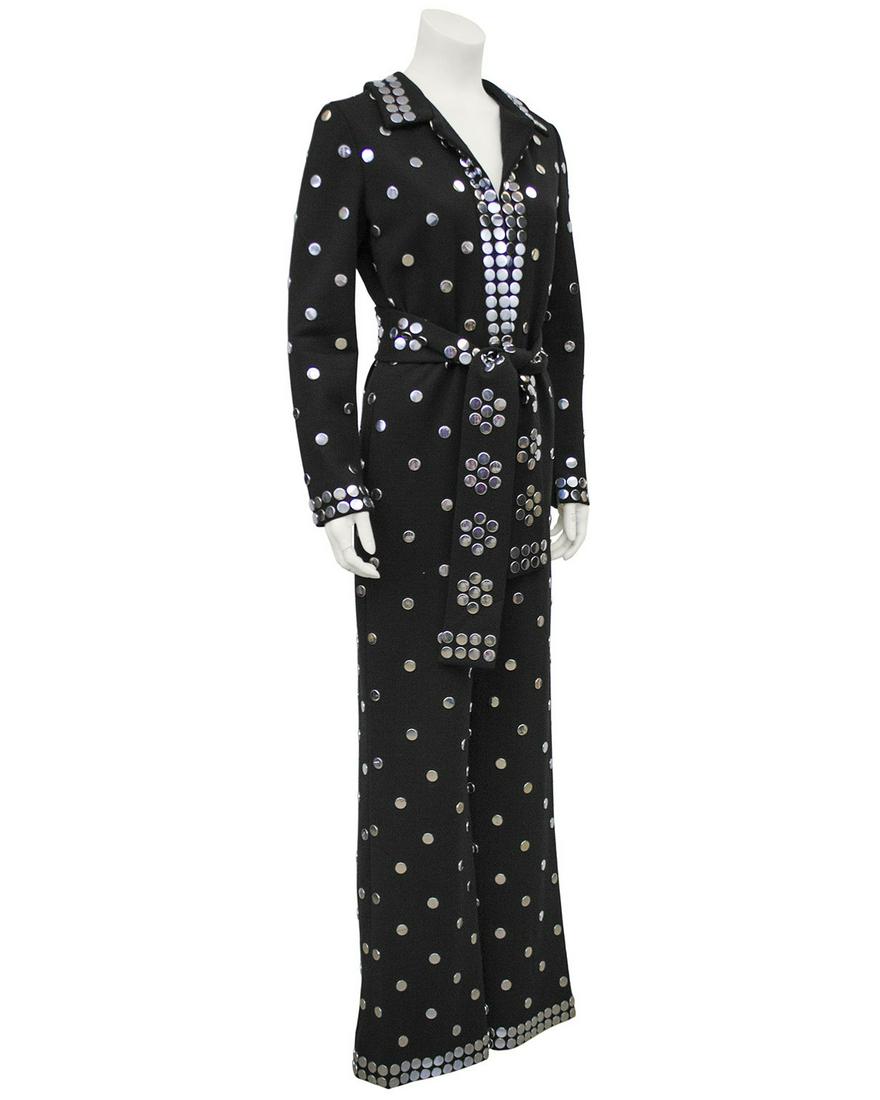 Donald Brooks Black Jersey Belted Jumpsuit with Silver: Sassy and sophisticated belted jumpsuit by Donald Brooks from the 1970's. Made of a black synthetic jersey fabric with flat silver metal studs throughout. Deep v-neck can be made more modest with a ro