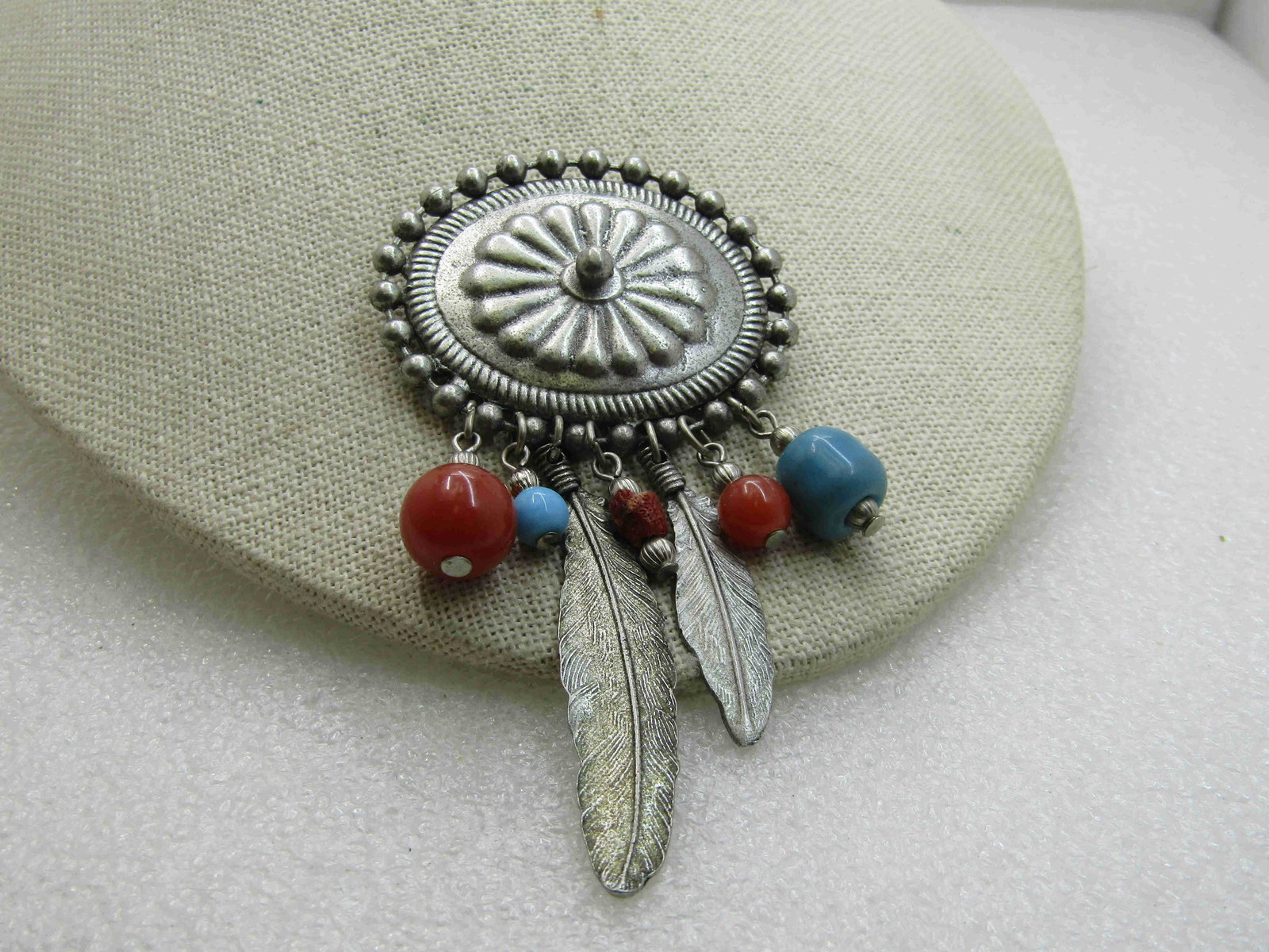 Vintage Southwestern Concho Feather Brooch, Silver: Vintage Southwestern Concho Feather Brooch, Silver Tone, 3.75" by 2" wide. This has danglign feather accents and faux carnelian and turquoise beads that also dangle from the concho. Brushed silver ton