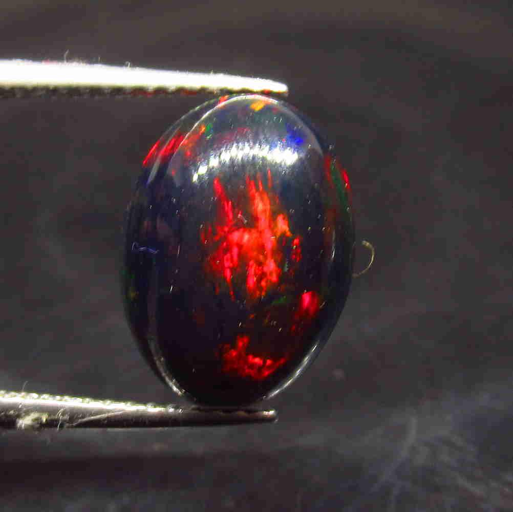 2.48 Ctw Natural Ethiopian Black Fire Opal Oval Cab: No Reserve! Title: 2.48 Ctw Natural Ethiopian Black Fire Opal Oval Cab Stone Clarity: Translucent Gemstone: Natural Black Opal Carat Weight: 2.48 Size/Dimensions: 12.70 x 9.40 x 4.50 mm Additional Inf