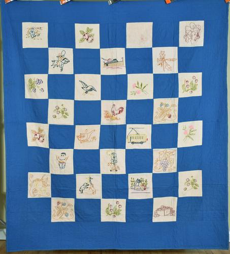 Whimsical 20's Pictorial Quilt: 20's cotton pictorial quilt, hand embroidered and hand quilted, with a medium blue background and a variety of detailed blocks featuring a cowboy, roller skater, cruise ship trolley, strawberries, gra