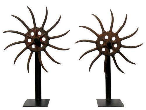 Decorative pair of old cultivator wheels mounted on: Title: Decorative pair of old cultivator wheels mounted on bases Additional Information: This is a pair of old cultivator wheels mounted on bases. They have a very decorative form, unlike many that we