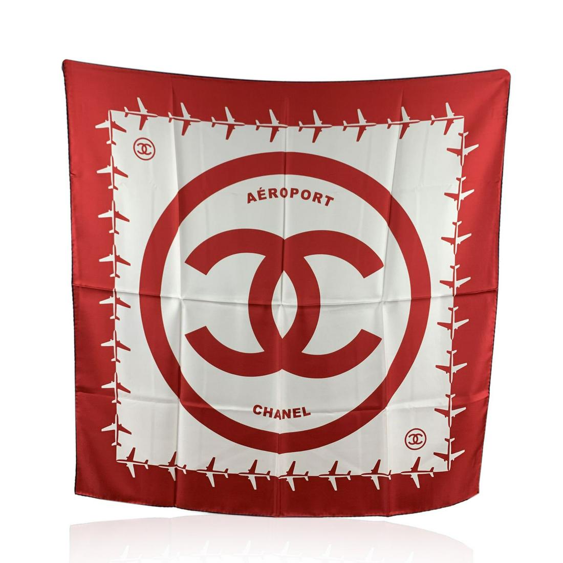Chanel Red and White Aeroport Airline Silk Scarf CC: Chanel 'Aeroport' silk scarf in red and white colors from the 2016 Airline collection. Contrast dark borders. Big Chanel CC logo in the center surrounded by red and white airplanes. Rolled edges. Comp