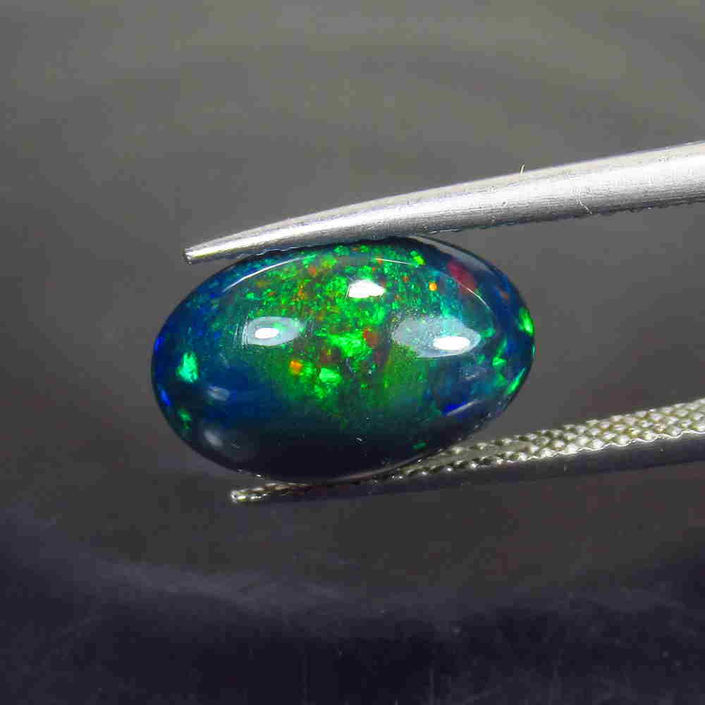 2.62 Ctw Natural Ethiopian Black Fire Opal Oval Cab: No Reserve! Title: 2.62 Ctw Natural Ethiopian Black Fire Opal Oval Cab Stone Clarity: Translucent Gemstone: Black Opal Carat Weight: 2.62 Size/Dimensions: 12.70 x 8.50 x 5.20 mm Additional Information