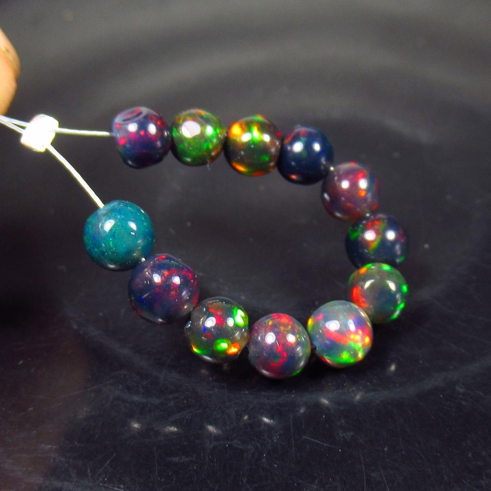 4.26 Ct Natural 12 Drilled Black Fire Opal Ball Beads: No Reserve! Title: 4.26 Ct Natural 12 Drilled Black Fire Opal Ball Beads Stone Clarity: Translucent Gemstone: Natural Black Opal Beads Carat Weight: 4.26 Dimensions: 4.00 to 4.50 mm / 12 PC's Addition