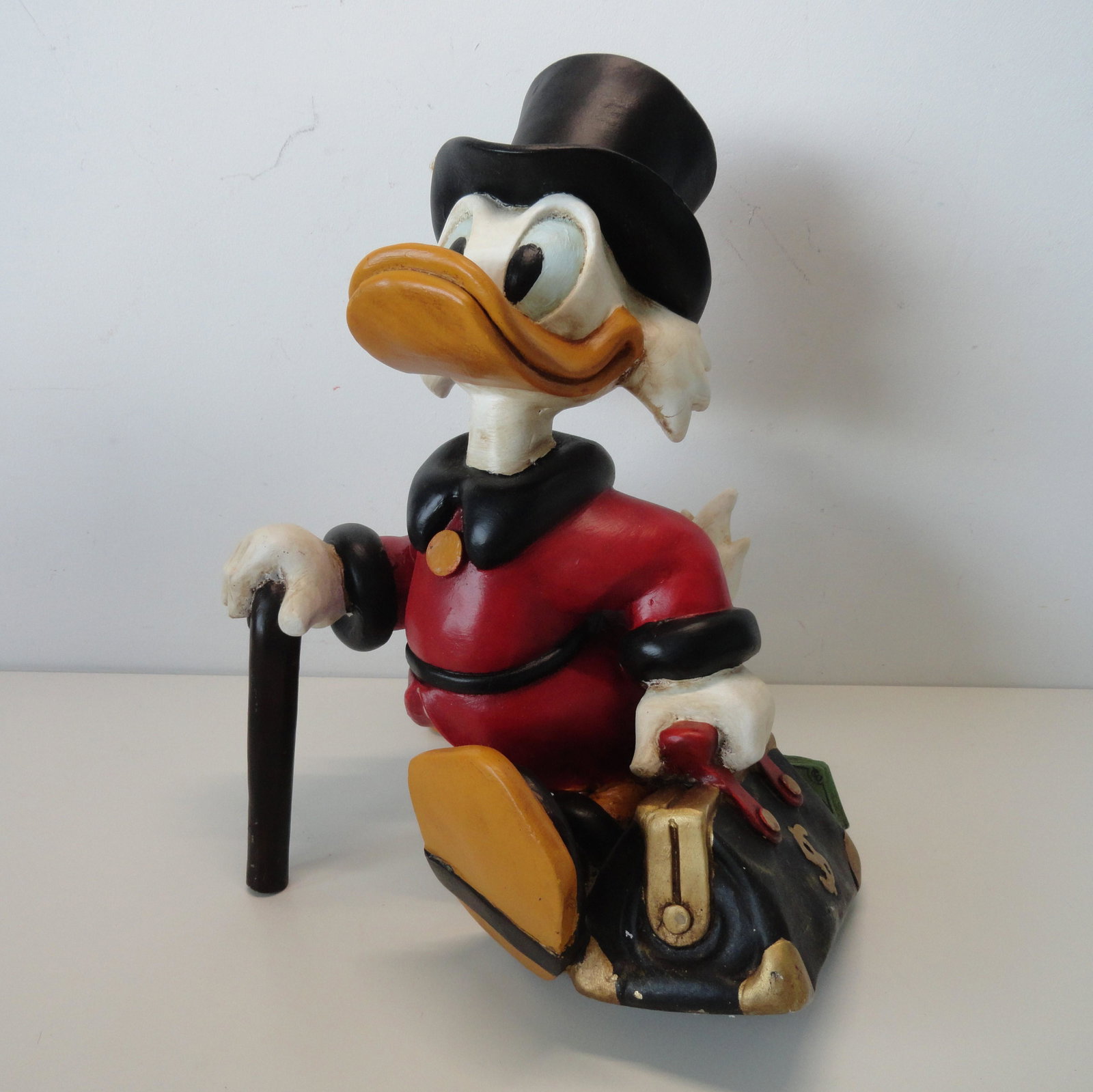 Scrooge McDuck with a suitcase full of money: Title: Scrooge McDuck with a suitcase full of money Date/Period: 1980's Materials: Polyester Dimensions: Approximately 36 cm high, 34 cm wide and 24 cm deep. Additional Information: Magnificent, vinta