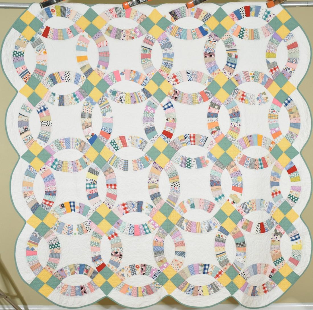 Well Quilted 30's Double Wedding Ring Quilt: 30's cotton 30's double wedding ring quilt, all hand pieced and hand quilted with a scalloped edge. It measures 72" X 74" and has superb hand quilting, with quilting along the rings and in straight li