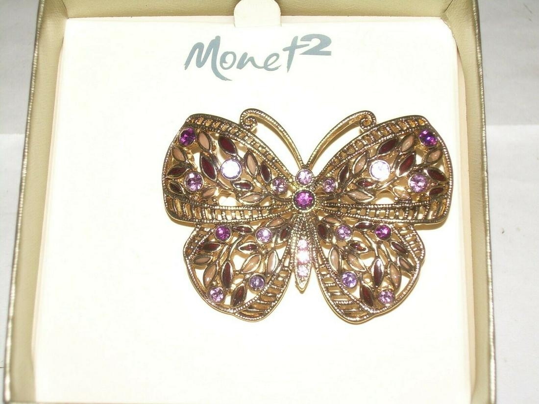 Vintage Monet Butterfly Brooch - Gold Tone With: This lovely vintage Monet brooch is detailed in gold tone. The wings have a leaf accent and have different shades of purple rhinestones throughout. Reserve: $15.00 Shipping: Domestic: Flat-rate of $5.