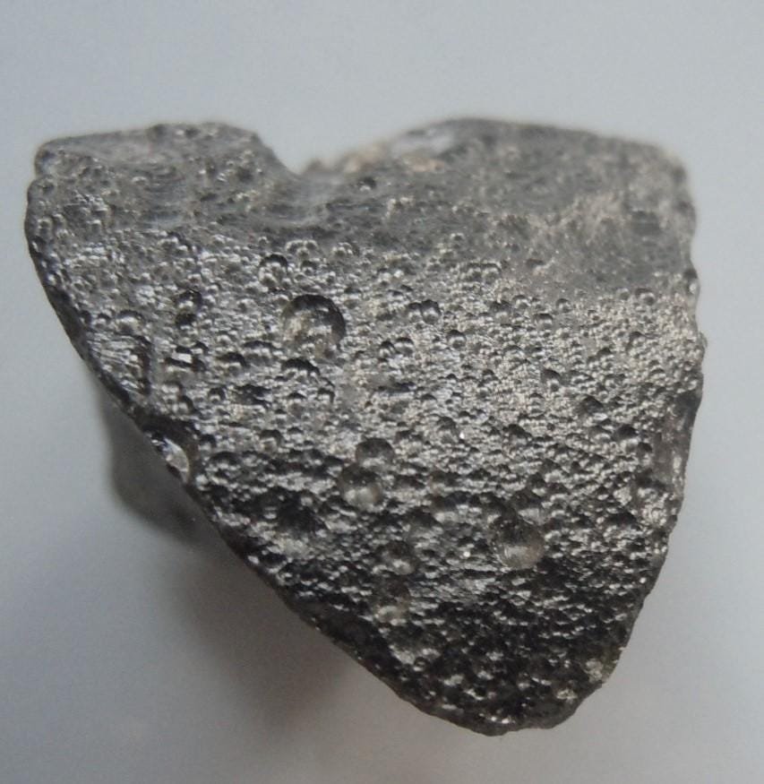 PHILIPPINITE TEKTITE - FROM METEORITE IMPACT: Title: PHILIPPINITE TEKTITE - FROM METEORITE IMPACT Origin: Paracale, Camarines Norte, Luzon, Philippines Size: 2x1.5x1.5 cm / 5 gram Description: 1/4 sphere rizalite/philippinite tektite. glossy with