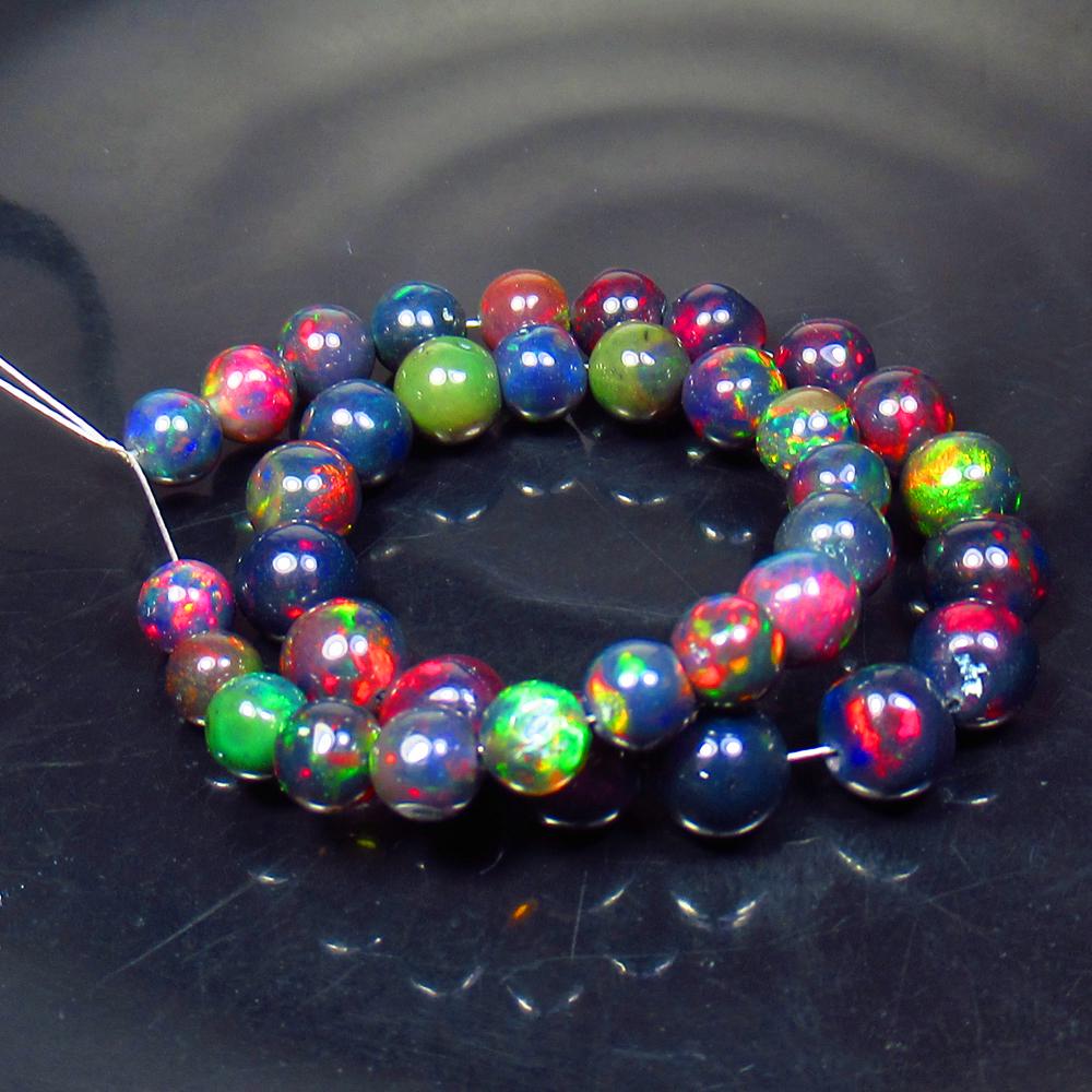 23.46 Ct Natural 36 Drilled Black Fire Opal Ball Beads: Title: 23.46 Ct Natural 36 Drilled Black Fire Opal Ball Beads Stone Clarity: Translucent Gemstones: Natural Black Opal Beads Carat Weights: 23.46 Size/Dimensions: 4.50 to 5.90 mm / 36 PC's Additional 