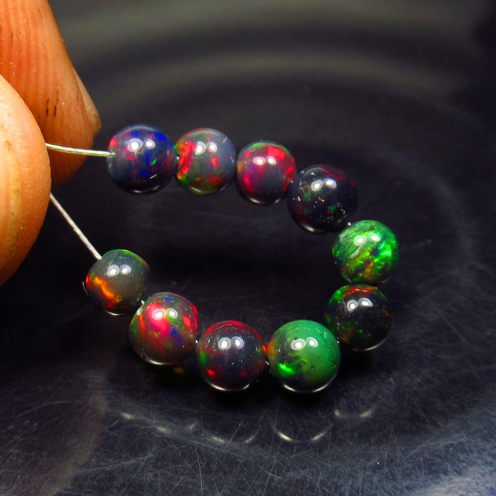4.25 Ctw Natural 10 Drilled Black Fire Opal Ball Beads: No Reserve! Title: 4.25 Ctw Natural 10 Drilled Black Fire Opal Ball Beads Stone Clarity: Transparent Gemstone: Black Opal Beads Carat Weight: 4.25 Size/Dimensions: 4.30 to 4.80 mm / 10 PC's Additional