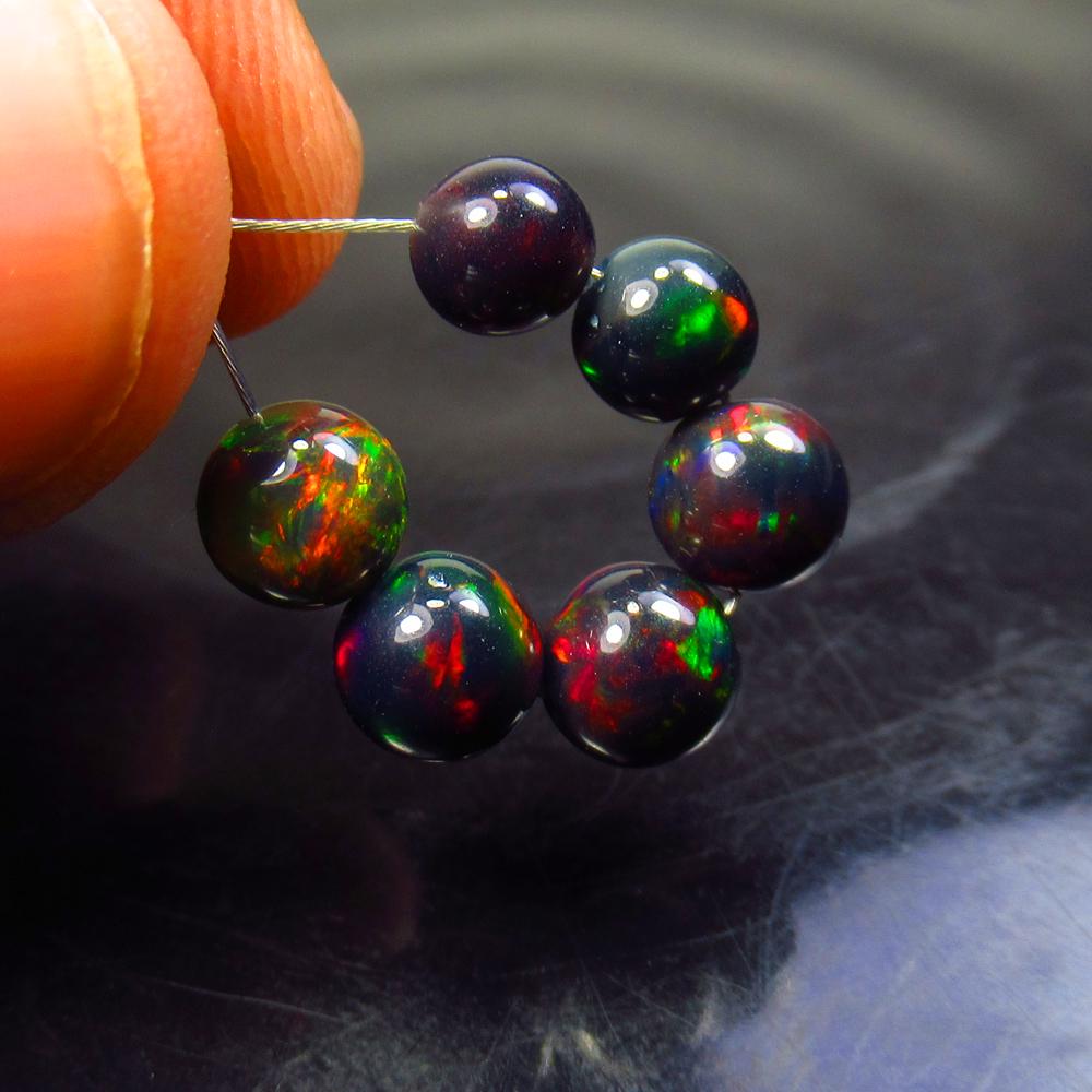 4.86 Ctw Natural 6 Drilled Black Fire Opal Ball Beads: Title: 4.86 Ctw Natural 6 Drilled Black Fire Opal Ball Beads Stone Clarity: Translucent Gemstone: Black Opal Beads Carat Weight: 4.86 Size/Dimensions: 5.10 to 5.90 mm / 6 PC's Additional Information: 