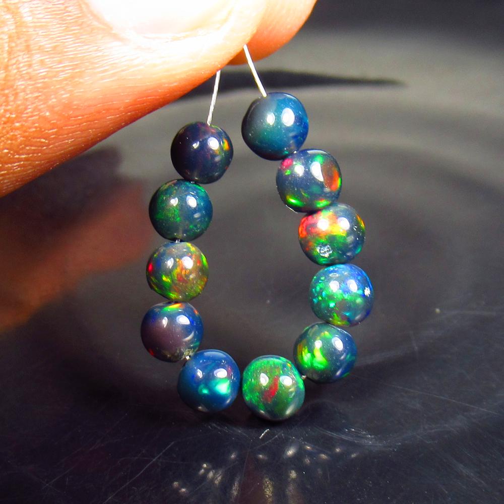 3.71 Ctw Natural 12 Drilled Black Fire Opal Ball Beads: Title: 3.71 Ctw Natural 12 Drilled Black Fire Opal Ball Beads Stone Clarity: Translucent Gemstone: Black Opal Beads Carat Weight: 3.71 Size/Dimensions: 4.30 to 4.60 mm / 12 PC's Additional Information