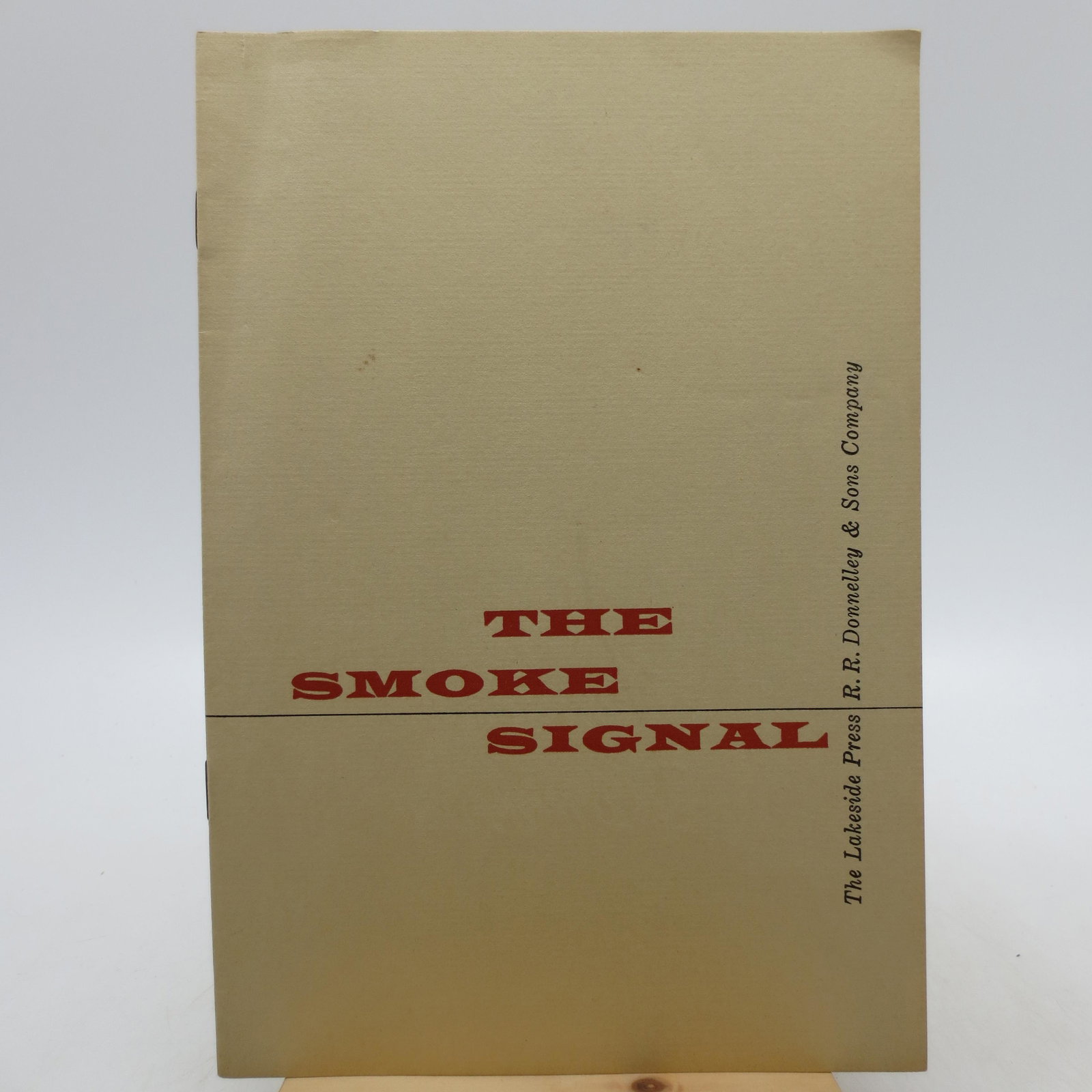 The Smoke Signal: Title: The Smoke Signal Description: Paperback stapled pamphlet. *Rare* First Edition. Clean pages with no markings or marginalia. 9 pp. Clean cover with red and black lettering; the top left corner o