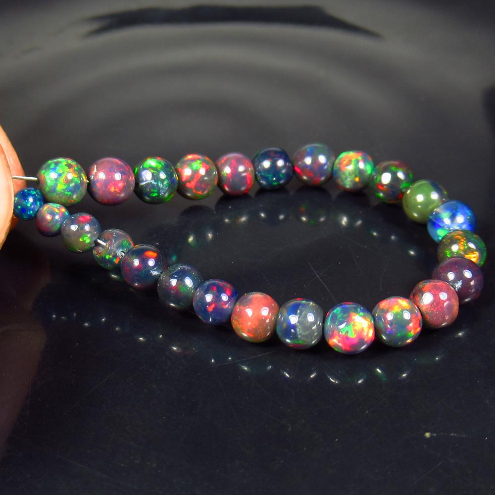 8.03 Ctw Natural 25 Drilled Black Fire Opal Ball Beads: Title: 8.03 Ctw Natural 25 Drilled Black Fire Opal Ball Beads Stone Clarity: Translucent Gemstones: Black Opal Beads Carat Weights: 8.03 Size/Dimensions: 3.00 to 4.60 mm / 25 PC's Additional Informati