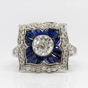 Platinum Old Mine Cut Diamond and French Cut Sapphire: One central 1ctw old mine cut diamond of H-VS1 quality is accented with 20 natural French cut sapphires. The flower design is framed by 36 old mine cut diamonds of H-VS1 quality that weigh 0.50ctw. 