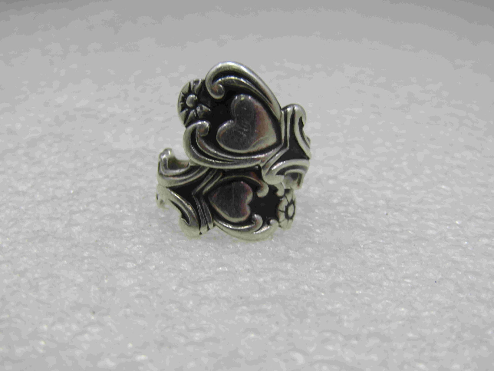 Vintage Sterling Avon Treasured Heart Spoon Ring,: Vintage Sterling Avon Treasured Heart Spoon Ring, Adjustable Sz. 5-10. 4.53 Gr., 1970's. this has a bypass design with hearts in a spoon-like design. The ring is appx. 1" down the finger and covers th