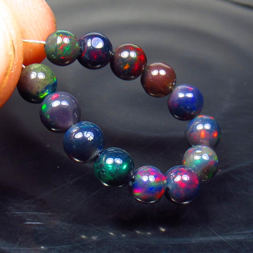 5.40 Ctw Natural 13 Drilled Black Fire Opal Ball Beads: No Reserve! Title: 5.40 Ctw Natural 13 Drilled Black Fire Opal Ball Beads Stone Clarity: Translucent Gemstones: Black Opal Beads Carat Weights: 5.4 Size/Dimensions: 4.40 to 4.90 mm / 13 PC's Additiona