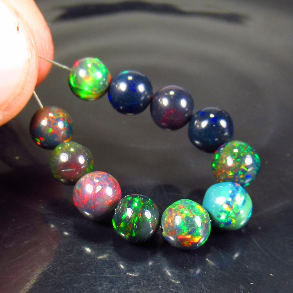 11.05 Ctw Natural 11 Drilled Black Fire Opal Ball Beads: Title: 11.05 Ctw Natural 11 Drilled Black Fire Opal Ball Beads Stone Clarity: Transparent Gemstones: Black Opal Beads Carat Weights: 11.05 Size/Dimensions: 6.00 to 6.20 mm / 11 PC's Additional Informa