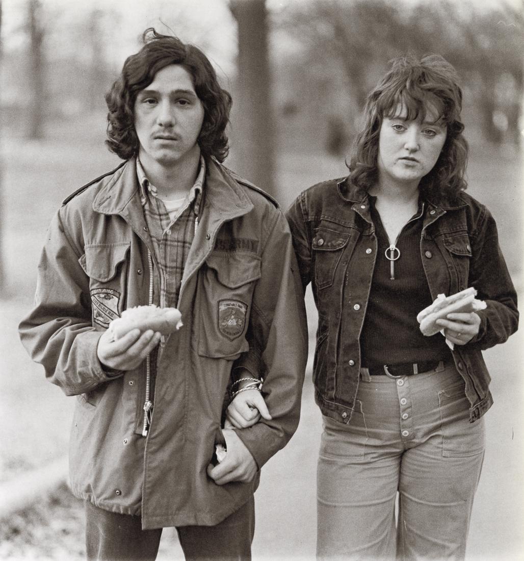 DIANE ARBUS - A Young Man, His Girlfriend, NYC, 1971: Artist: Diane Arbus Title: A Young Man and His Girlfriend with Hot Dogs in the Park, NYC, 1971 Medium: Photo Litho, 1972, USA Dimensions: 8x8.55" Description: Heat Wax Mounted on 11x14" Conservation B