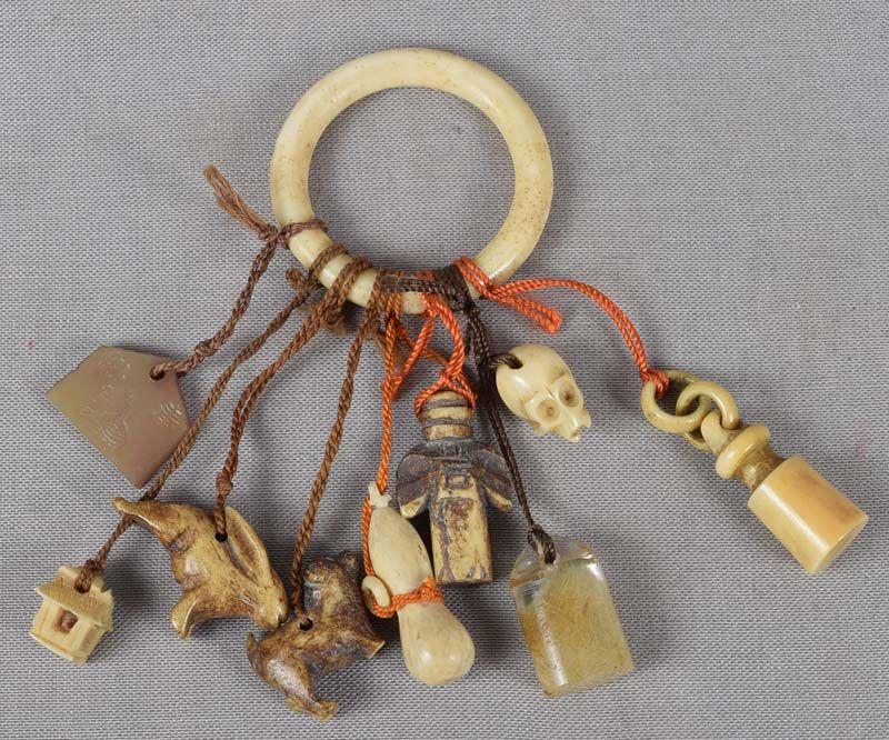 19c netsuke 9 CHARMS: Unusual 19th century assembly of 9 small staghorn and rock crystal charms tied together to serve as netsuke. Charms are: a devotional plaque with impressed image of a zebra, a thatched roof hut, a lea