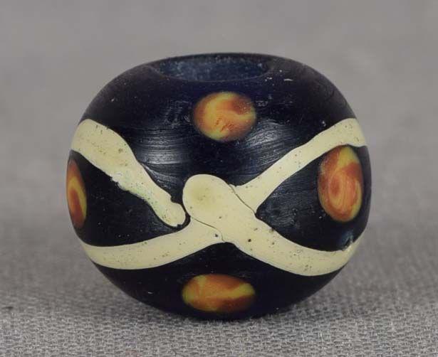 19c glass OJIME netsuke slide: 19th century glass ojime (slide bead for tightening the cord going from netsuke to inro) in flattened ball form with dark blue body with differently colored inclusions and wavy yellow lines. Beautiful