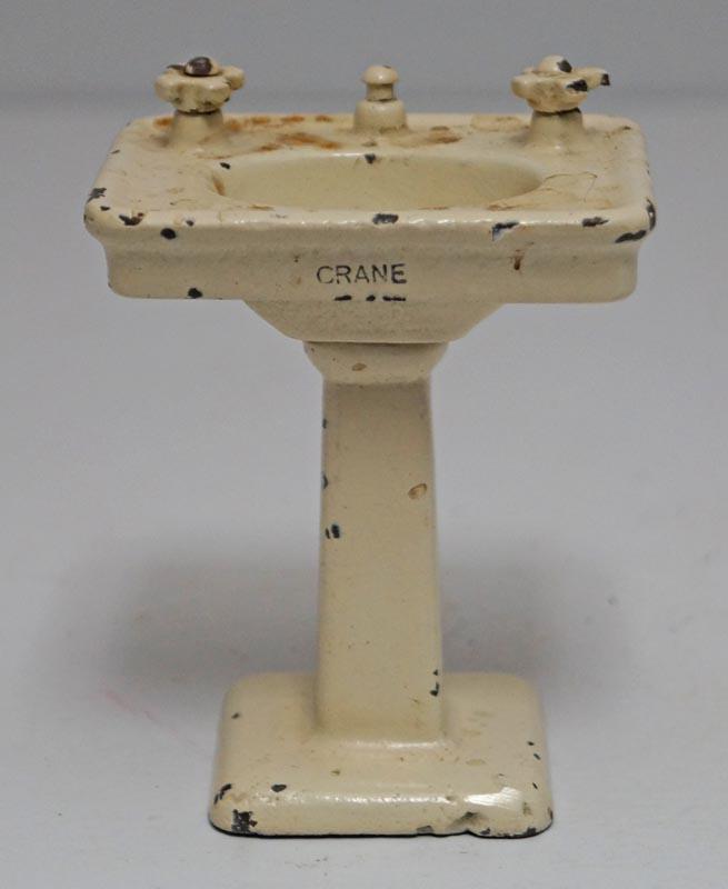 Antique Crane Pedestal Lavatory Sink Cast Iron Toy: Title: Antique Crane Pedestal Lavatory Sink Cast Iron Toy Date/Period: Circa 1927. Dimension: 3 3/4" tall x 2 7/8" wide x 2 1/4" deep. Additional Information: Offering for sale an Antique Pedestal Lav