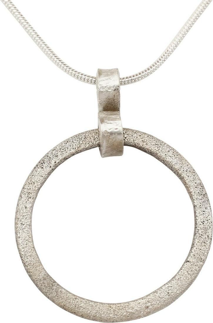 VIKING PROTECTIVE BROOCH NECKLACE C.870-1066: Cambridgeshire, England. Circular bronze, about 1" diameter with rounded edges and flat front and back. Surface lightly textured from burial. Worn in numbers on the surface of the jerkin, these small 