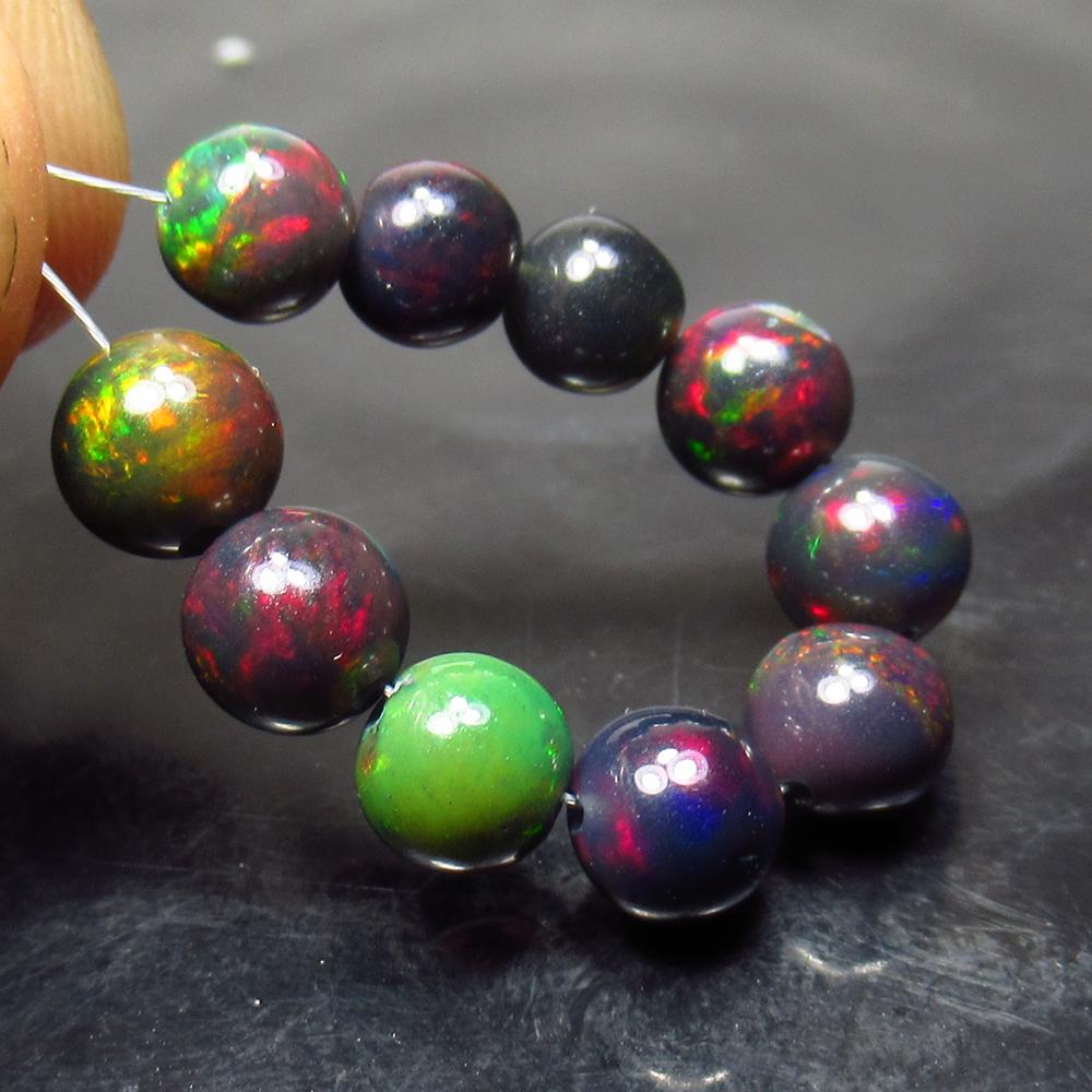 7.60 Ct Natural 10 Drilled Black Fire Opal Ball Beads: Title: 7.60 Ct Natural 10 Drilled Black Fire Opal Ball Beads Stone Clarity: Translucent Gemstone: Natural Black Opal Beads Carat Weight: 7.60 Size/Dimensions: 5.10 to 6.00 mm / 10 PC's Additional Info